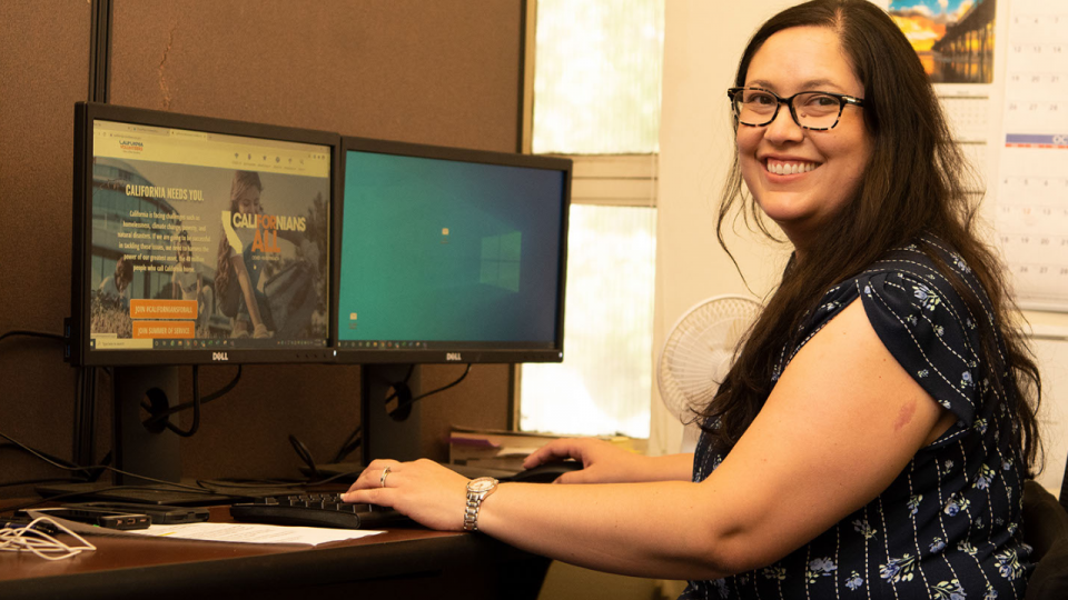 Latina at a computer smiling