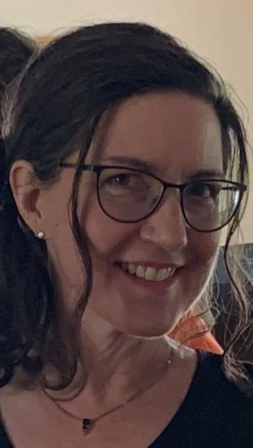 White woman wearing glasses smiling